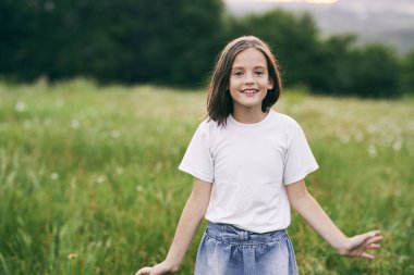 Genç tatlı kız çayırda eğleniyor.