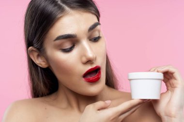 Cilt bakımı ve güzellik. Pembe arka planda kremalı güzel bir kadının portresi.