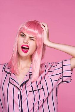 Stüdyoda poz veren pembe peruklu güzel bir kadın. 