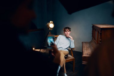 Genç besteci karanlık odada piyanonun başında oturuyor.      