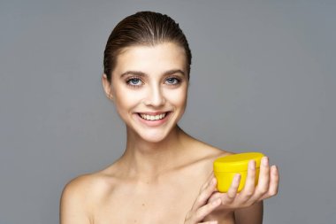 Kremalı güzel bir kadının stüdyo fotoğrafı, izole edilmiş bir arka planda güzellik ürünü.