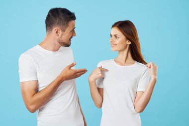 Stüdyoda izole edilmiş arka planda poz veren tişörtlü güzel bir çift.  