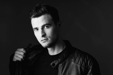 Stüdyoda poz veren yakışıklı bir genç. Siyah ve beyaz  