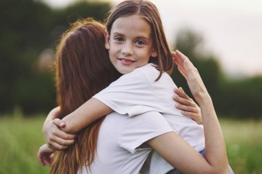 Genç anne ve kızı papatya tarlasında eğleniyorlar.