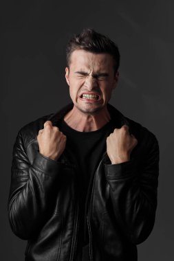 Genç yakışıklı duygusal adam stüdyoda poz veriyor.