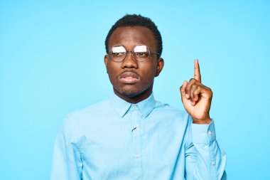 Genç Afrikalı bir adam mavi arka planda izole edilmiş.