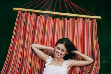 Genç ve güzel bir kadın hamakta dinleniyor.