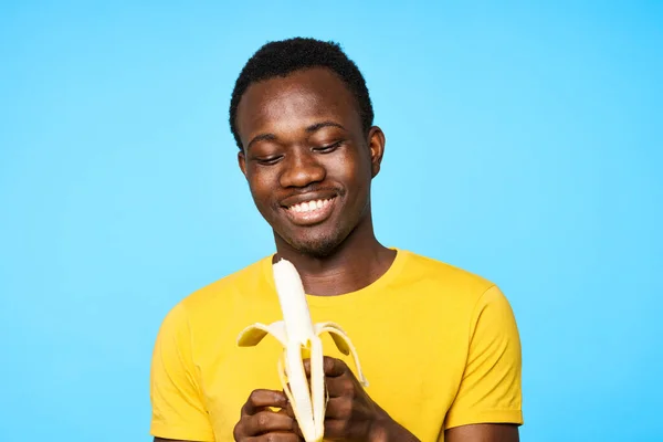 Young man with banana   isolated on blue background