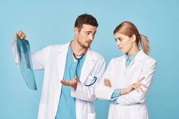 Studioaufnahmen Junge Ärztin Und Krankenschwester Betrachten Röntgenbild Vor Isoliertem Hintergrund — Stockfoto