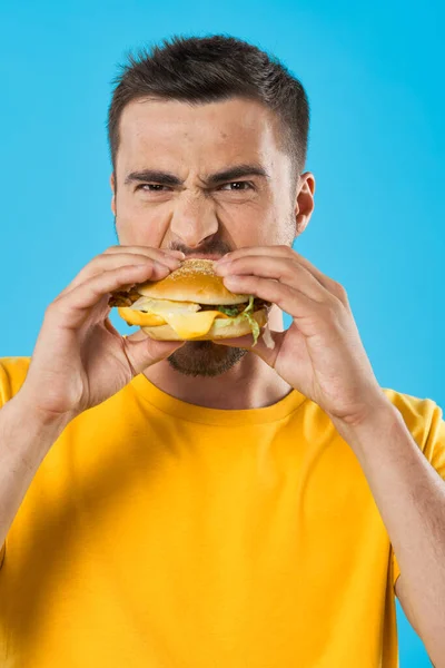 Stüdyoda Hamburger Yiyen Genç Adam — Stok fotoğraf
