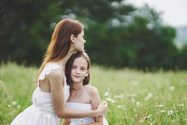 stock image Young mother and her daughter having fun on camomile field