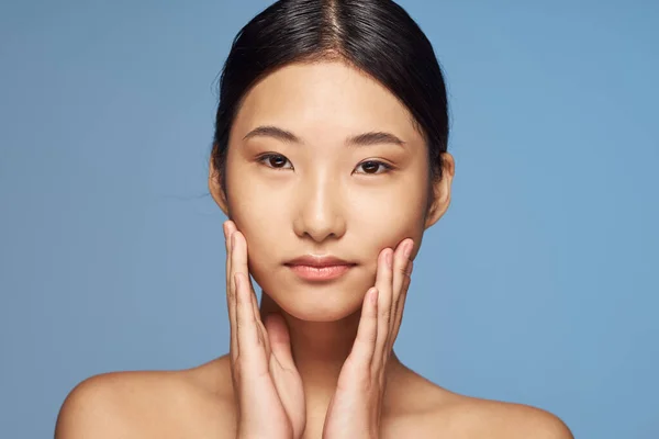 Portrait of young beautiful asian woman touching face    isolated