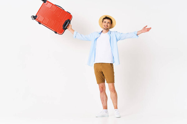 Young man with red suitcase in studio