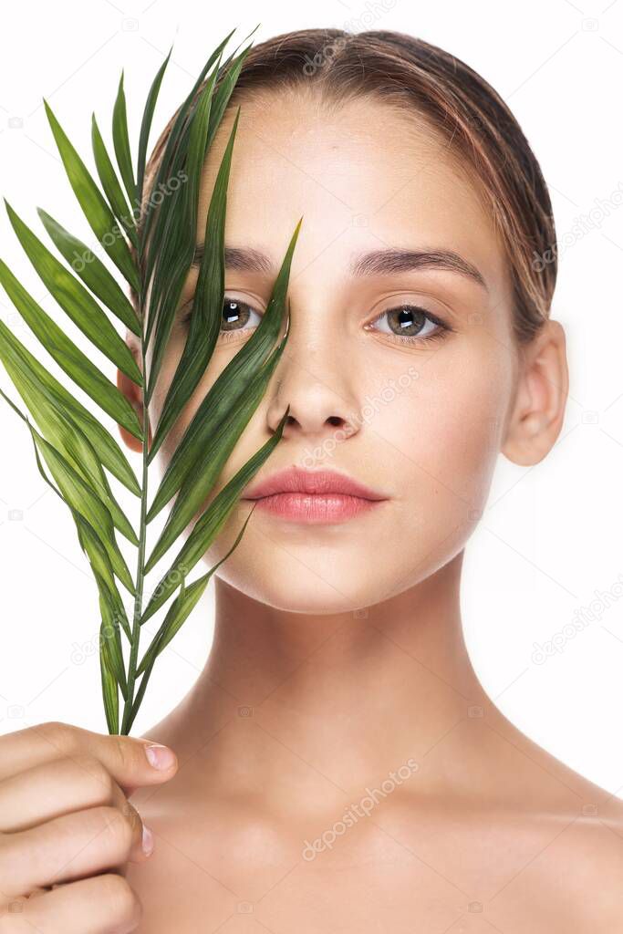 Young beautiful wman  posing with leaf in studio