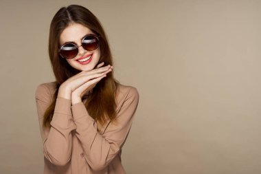 Stüdyoda poz veren güneş gözlüklü güzel bir kadın. 