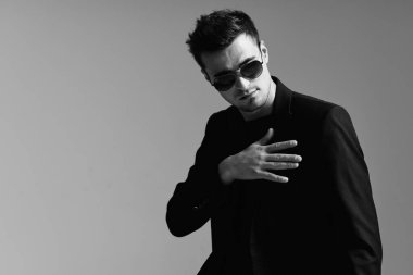 Stüdyoda güneş gözlüğü takan genç yakışıklı adam. 