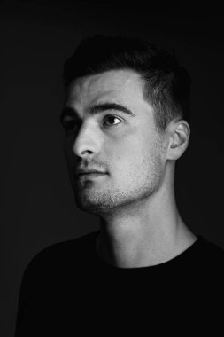 Stüdyoda poz veren yakışıklı genç adamın portresi. 