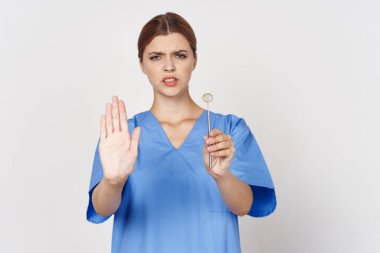 Genç hemşire diş aynası aletini tutuyor. jesti durdur