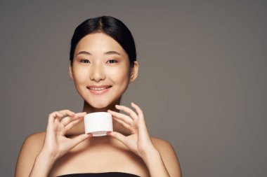 Genç, güzel, Asyalı, gülümseyen bir kadın. 