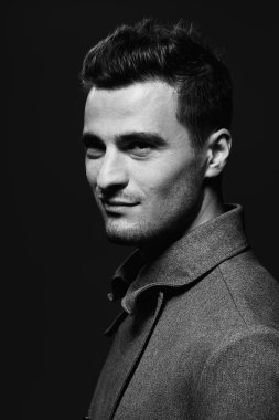 Stüdyo çekimi. Karanlık arka planda genç ve vahşi bir adamın portresi.  