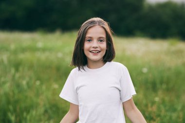 Genç tatlı kız papatya tarlasında eğleniyor.