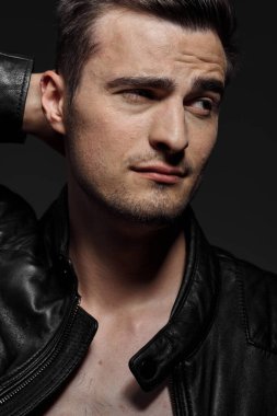 Stüdyoda poz veren siyah deri ceketli yakışıklı bir adamın portresi.. 