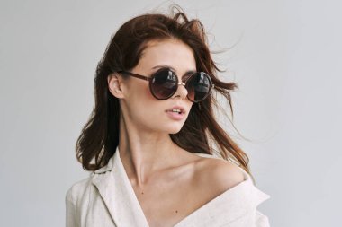 Stüdyoda poz veren güneş gözlüklü güzel bir kadın.  