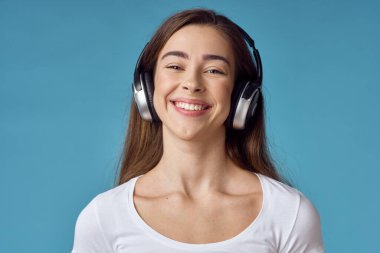 Kulaklıklı genç bir kadın müzik dinliyor.