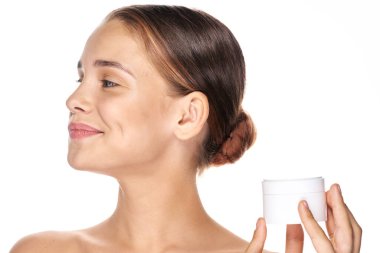 Genç ve güzel bir kadın krem tutuyor. 