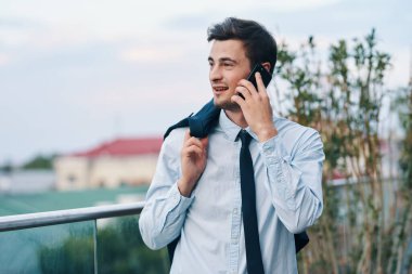 Sokakta akıllı telefonu olan yakışıklı bir iş adamı.