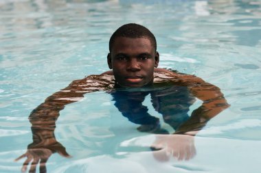 Havuzda poz veren genç yakışıklı adam.