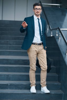 Sokakta çanta taşıyan genç bir iş adamı.