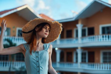   Tropik tatil köyünde hasır şapkalı genç bir kadın. 
