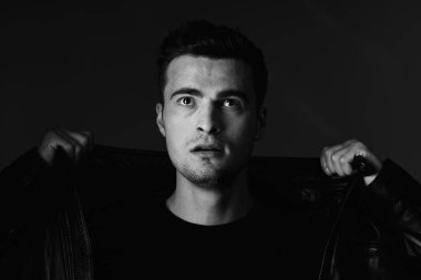 Stüdyoda poz veren yakışıklı bir genç. Siyah ve beyaz  