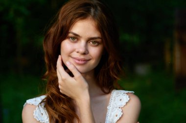 Yaz bahçesinde poz veren güzel bir kadın. 