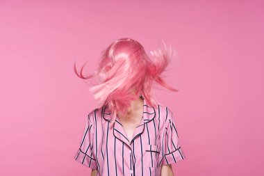 Stüdyoda poz veren pembe peruklu güzel bir kadın. 