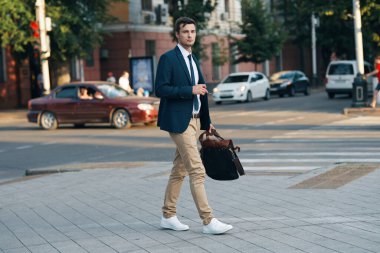 Genç işadamı sokakta yürüyor.