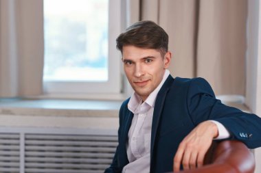 Genç ve yakışıklı bir adam ofiste oturuyor. 