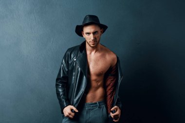 Stüdyoda poz veren şapkalı genç, yakışıklı bir adam.