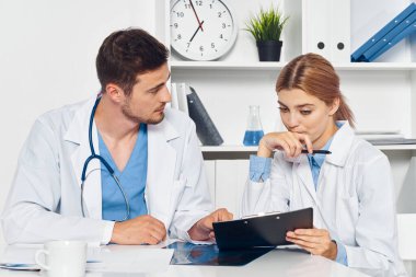 Hastane ofisinde çalışan hemşire ile genç bir doktor. 