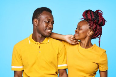 Stüdyoda mavi arka planda poz veren genç ve güzel bir çift