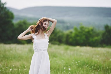 Kırsalda poz veren genç bir kadın. 
