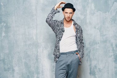 Stüdyoda poz veren şapkalı genç, yakışıklı bir adam.