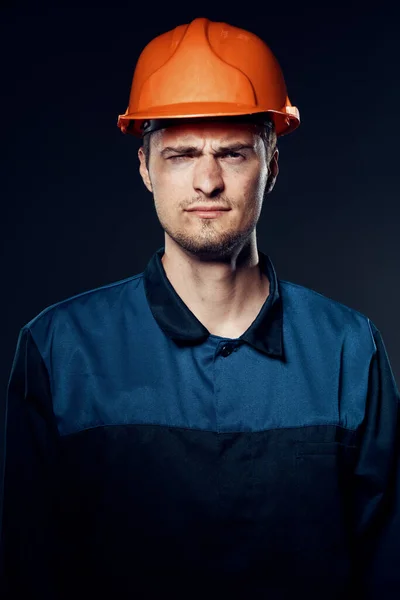 young man in work wear and helmet. Studio shot