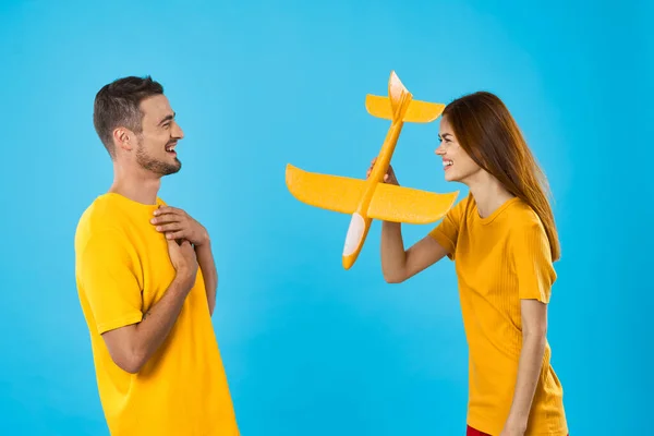 Νεαρό Όμορφο Ζευγάρι Παίζει Κίτρινο Παιχνίδι Αεροπλάνο Μπλε Φόντο — Φωτογραφία Αρχείου