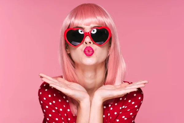 身穿粉色假发 戴着太阳镜的年轻漂亮女子站在演播室里 — 图库照片