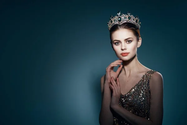 Beautiful woman with crown posing in studio. High quality photo