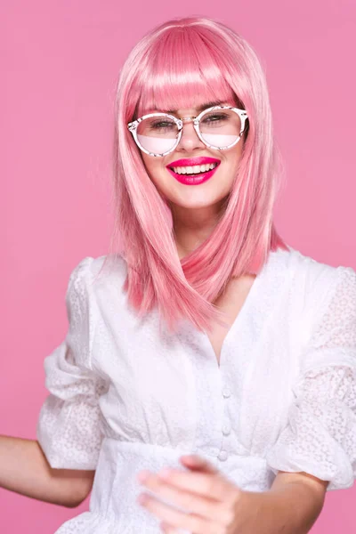 Young woman in pink wig and glasses  on pink background