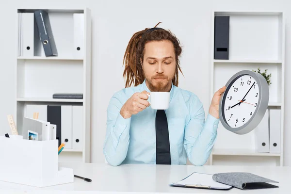 若いビジネスマンがコーヒーと一緒にオフィスに座っている — ストック写真