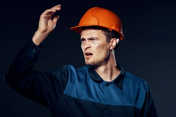 young angry man in work wear and helmet. Studio shot